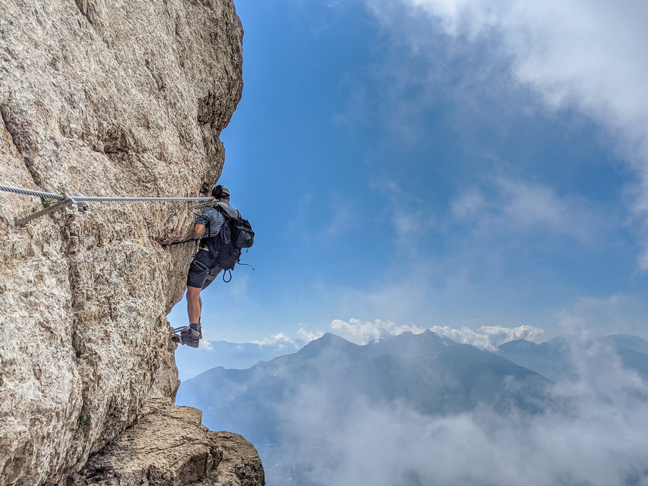 Man Climbing on Rocky Mountain Under Blue Sky